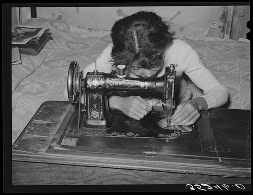 Wife of Pomp Hall, Negro tenant farmer, threading sewing machine. She makes practically all of the clothing for her family with the exception of such things as overalls, sweaters, etc. Creek County, Oklahoma. See general caption number 23