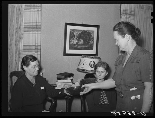 Hostess presenting prize which is a green glass bowl to the winner of a contest. The contest was to determine who could make the largest number of words from the letters in the word "Washington." Club meeting was on Washington's birthday. McIntosh County, Oklahoma