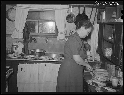 Hostess cutting and serving cake at home demonstration club meeting in McIntosh County, Oklahoma