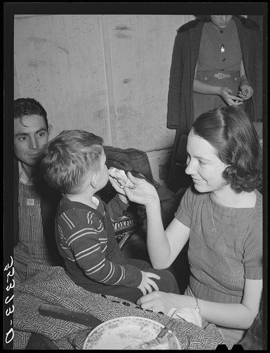 Farm mother feeding pie to her son while the father watches. Pie supper in Muskogee County, Oklahoma. See general caption number 24