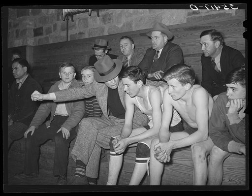 High school coach giving last minute instructions to substitute who is going into the game. Basketball game, Eufaula, Oklahoma