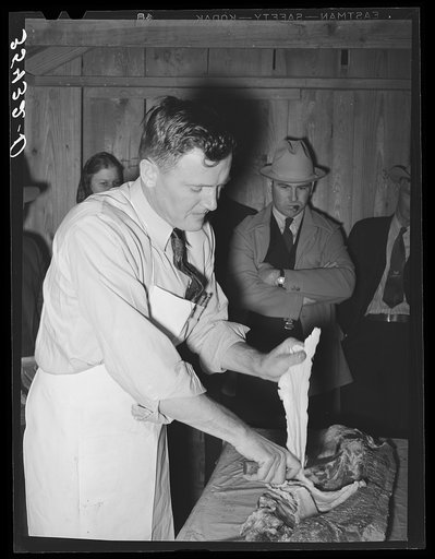 FSA (Farm Security Administration) supervisor who was formerly a meat cutter in a large packing plant giving an exhibition of meat cutting before a group of FSA officials at a district meeting. San Angelo, Texas