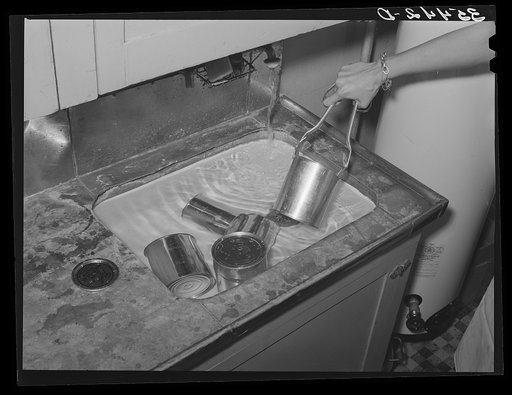 Putting sealed cans of vegetables which were cooked in a pressure cooker into a cold water bath for quickest cooling. This is a part of the demonstration of a FSA (Farm Security Administration) supervisor before a group of FSA officials at a district meeting. San Angelo, Texas