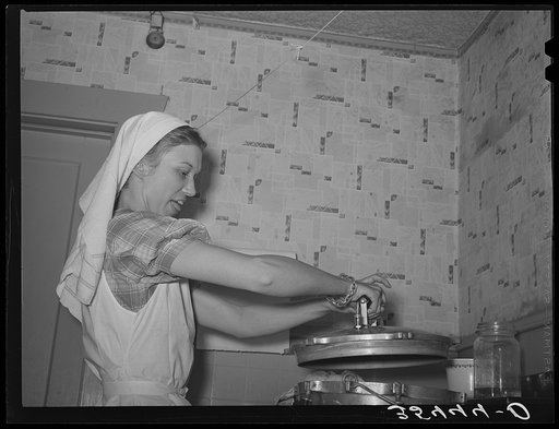 FSA (Farm Security Administration) supervisor removing the top pressure cooker during a demonstration of pressure canning before a group of FSA officials at a district meeting. San Angelo, Texas