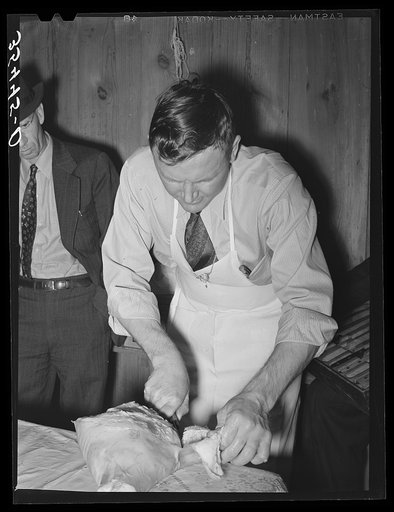 FSA (Farm Security Administration) supervisor who was formerly a meat cutter at a large packing plant giving a demonstration of meat cutting before a group of FSA officials at a district meeting. San Angelo, Texas