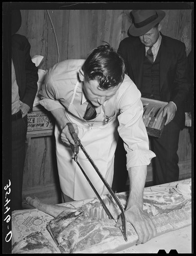 FSA (Farm Security Administration) supervisor who was formerly a meat cutter at a large packing plant giving a demonstration of meat cutting before a group of FSA officials at a district meeting. San Angelo, Texas