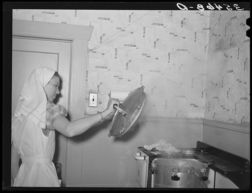 FSA (Farm Security Administration) supervisor giving a demonstration of pressure canning before a group of FSA officials at a district meeting at San Angelo, Texas. She is removing top of pressure cooker