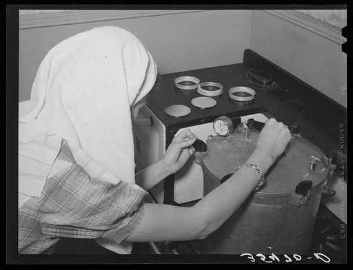 FSA (Farm Security Administration) supervisor giving a demonstration of pressure canning before a group of FSA officials and supervisors at a district meeting at San Angelo, Texas. She is loosening clamps which hold top of pressure cooker securely in place