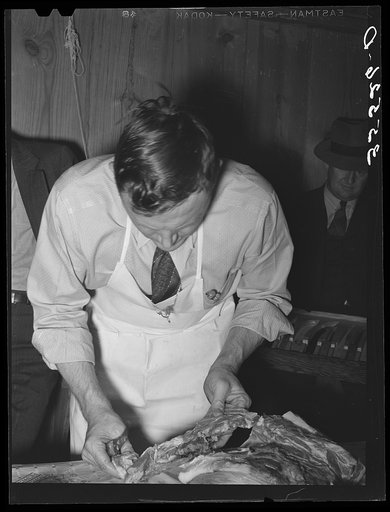 Untitled photo, possibly related to: FSA (Farm Security Administration) supervisor making sausage during a meat cutting demonstration before FSA officials and supervisors at a district meeting at San Angelo, Texas