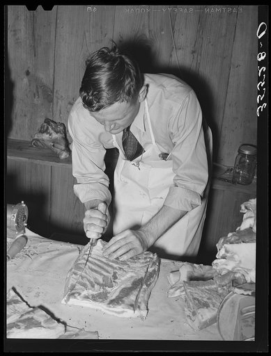 FSA (Farm Security Administration) supervisor giving a demonstration of meat cutting before a group of FSA officials and supervisor at a district meeting in San Angelo, Texas