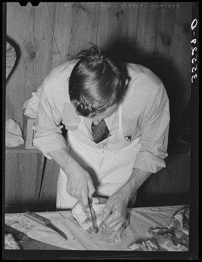 FSA (Farm Security Administration) supervisor giving a demonstration of meat cutting before a group of FSA officials and supervisor at a district meeting in San Angelo, Texas