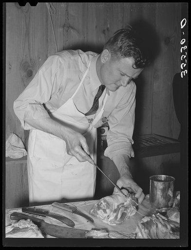 FSA (Farm Security Administration) supervisor sewing up a pork rolled roast during a meat cutting demonstration before a group of FSA supervisors and officials at a district meeting in San Angelo, Texas
