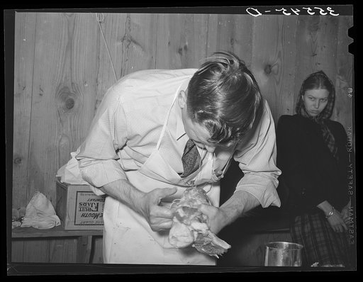 FSA (Farm Security Administration) supervisor tying a pork rolled roast during a meat cutting demonstration before FSA supervisors and officials at a district meeting. San Angelo, Texas