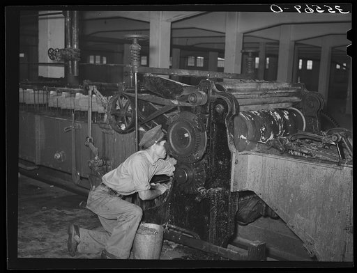 Workman cleaning wool scouring machine. San Marcos, Texas