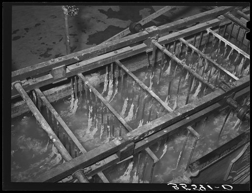 Detail of wool scouring machine. Metal forks pull the wool through the hot alkaline bath. Wool scouring plant, San Marcos, Texas