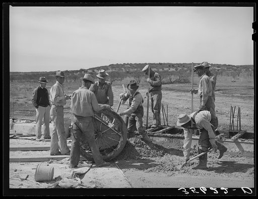 Road workers at the concrete mixing cart. Menard County, Texas