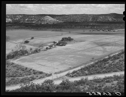 Farmhouse surrounded by trees and pasture for the grazing of sheep and goats in Kimble County, Texas