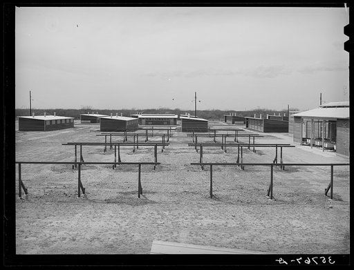 Clotheslines with laundry room at the right and row shelters in the background. Migratory labor camp, Sinton, Texas