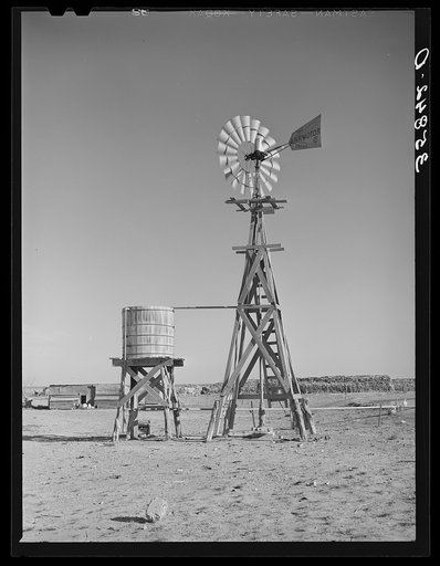 Windmill and water storage tank on farm on high plains. Gaines County, New Mexico