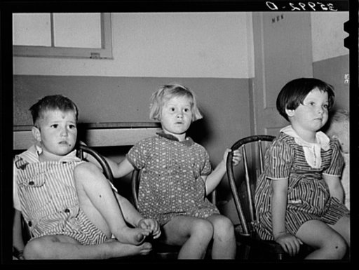 Children of migratory laborers listening to a story at the WPA (Work Projects Administration) nursery school at the Aqua Fria migratory labor camp. Arizona