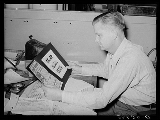 Secretary of the United Producers and Consumers Cooperative examining advertising material. Phoenix, Arizona