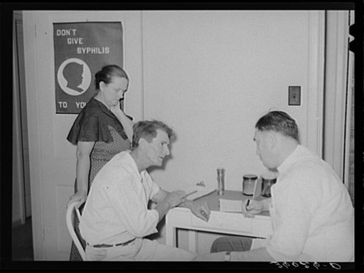 Doctor at clinic taking case history of agricultural worker. Agua Fria migratory labor camp. Arizona