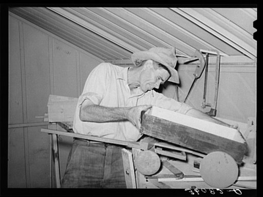Migratory agricultural laborer making toys for the WPA (Work Projects Administration) nursery school at the Agua Fria migratory labor camp. Arizona