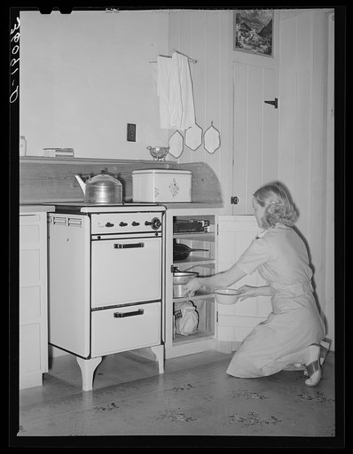 Wife of member of the Arizona part-time farms, Chandler Unit, Maricopa County, Arizona, at her kitchen stove
