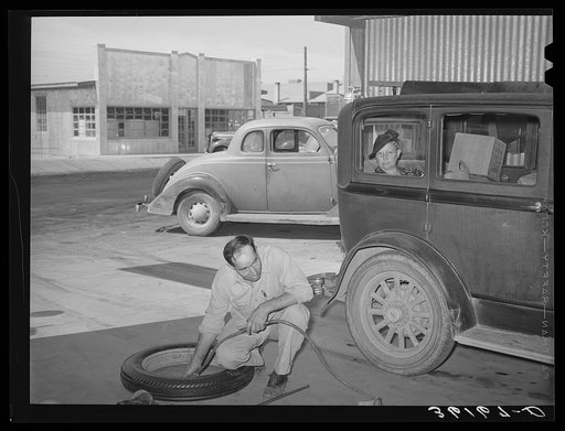 Inflating a new tire for installation on car of member of the United Producers and Consumers Cooperative. Phoenix, Arizona