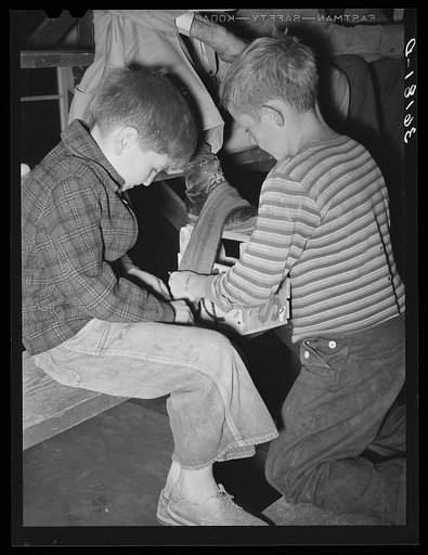 Children of migrant agricultural workers make some spending money by shining shoes at the Agua Fria labor camp. Arizona