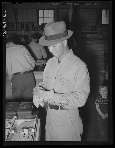 Member of the United Producers and Consumers Cooperative of Phoenix, Arizona, trying on a pair of gloves