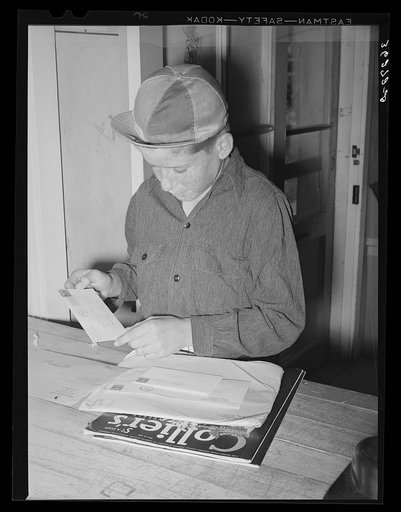 Little boy receiving his family's mail at the post office of the Casa Grande Valley Farms. Pinal County, Arizona
