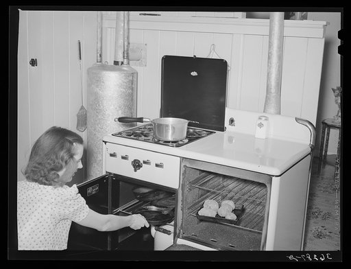 Wife of member of the Casa Grande Valley Farms working at range in her kitchen. Pinal County, Arizona