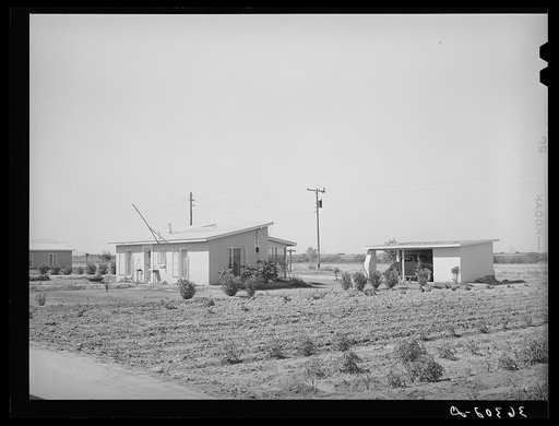 House and garage with garden in foreground at the Casa Grande Valley Farms. Pinal County, Arizona