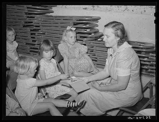 Children dropping their collection nickles on the open Bible at the Sunday school at the community house of the Casa Grande Valley Farms. Pinal County, Arizona