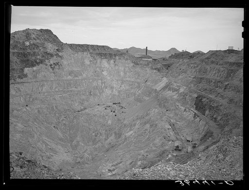 Sacramento Pit copper mine at Bisbee, Arizona. This is a pit 435 feet deep. In 1911 a shaft was sunk into the slopes of the east wall. In 1917 a dynamite charge blew off the top rock of the crown and dredges were worked to excavate the pit's ore bodies. By 1931 the pit floor was too narrow for dredg