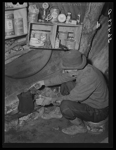 Eugene Davis, gold prospector, making a pot of coffee in his shack on his diggings. Pinos Altos, New Mexico