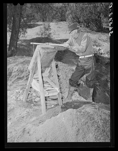 Eugene Davis, gold prospector, operating a papago (dry washer) at his diggings. Pinos Altos, New Mexico