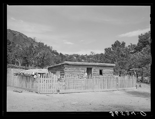 Home of Jack Whinery at Pie Town, New Mexico. The original dugout house cost him thirty cents for nails, and took him ten days to build. Since then two small sleeping rooms have been added. The fence was built by Mrs. Whinery after her husband had cut the slats