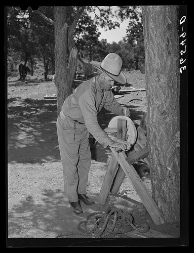 Faro Caudill's father sharpening his knife. This man was a cowboy and rancher in the section before the homesteaders came in. Pie Town, New Mexico
