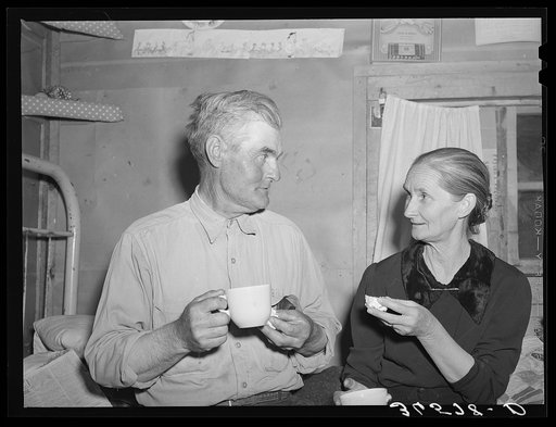Mr. and Mrs. Besson eating cake and coffee at a Forty-two party at their home. Pie Town, New Mexico. They farmed in Oklahoma near Frederick before homesteading to Pie Town
