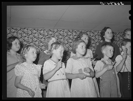 Children at the private school held in the Farm Bureau building keeping time with homemade musical instruments with a phonograph. Pie Town, New Mexico