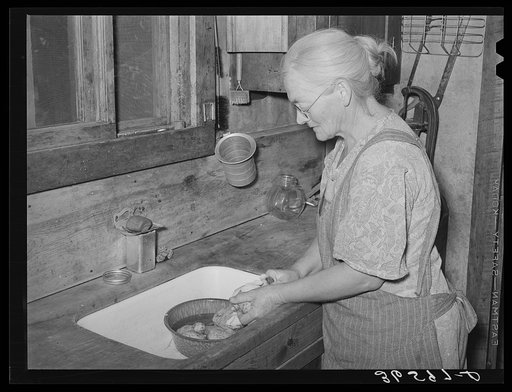 Homesteader's wife peeling potatoes for dinner. Pie Town, New Mexico