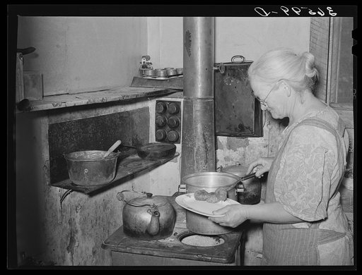 Mrs. George Hutton dishes up sausage made from her own hogs and canned last winter. Pie Town, New Mexico