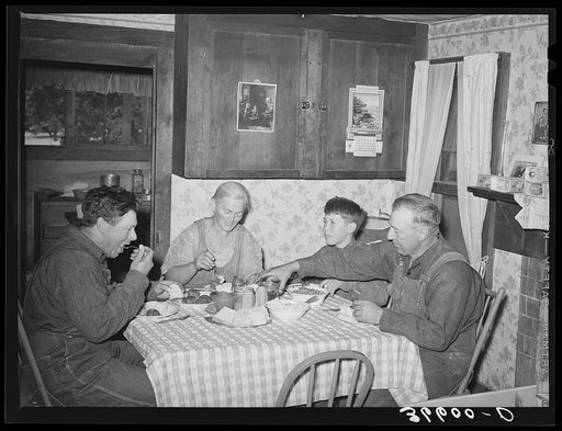 Mr. and Mrs. George Hutton, their son, and grandson at dinner. The younger Mr. Hutton homesteaded his own place, but he is now a widower and lives and farms with his father. Pie Town, New Mexico