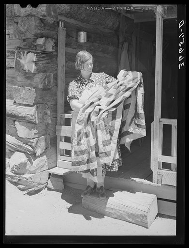 Untitled photo, possibly related to: Mrs. Bill Stagg exhibiting a quilt made from tobacco sacks which she ripped up, dyed, and pierced. Nothing is wasted on these homesteading farms. Pie Town, New Mexico