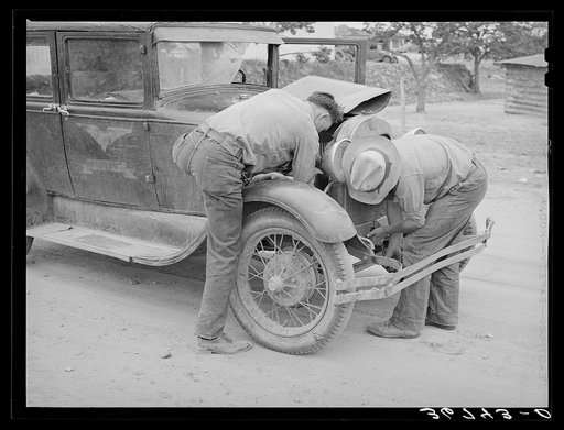 Untitled photo, possibly related to: Garage owner and farmer working on a car. Pie Town, New Mexico. The young man who owns the filling station, blacksmith shop, and garage came out from Texas when he could not get work either on the farms or in the farming community towns there