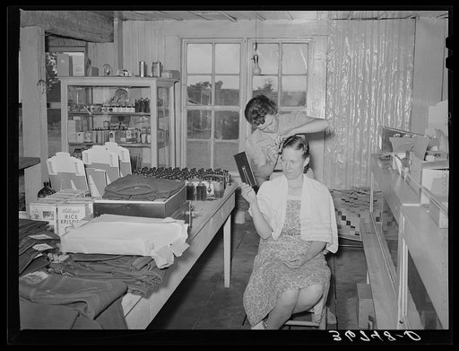 A neighbor fixes the grocery clerk's hair at Pie Town, New Mexico