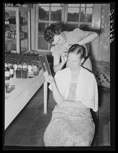 A neighbor fixes the grocery clerk's hair at Pie Town, New Mexico