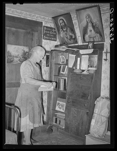 Mrs. George Hutton, homesteader, in front of her bookcase. Pie Town, New Mexico
